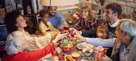 multi-generational, multi-cultural family doing a toast at the family dinner table