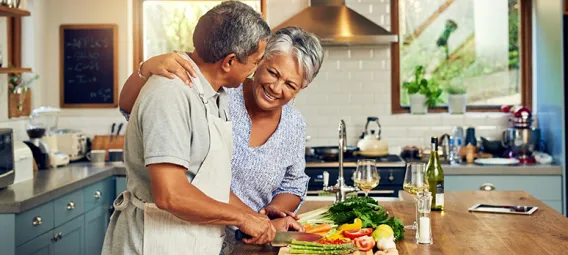  happy mature couple cooking a meal together at home.