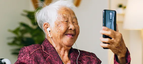 Asian old senior making video call via mobile phone talking with family