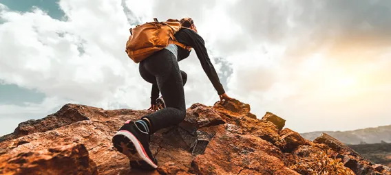 Low Angle View Of Woman Climbing On Cliff