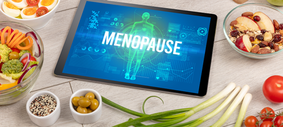Tablet with Menopause on the screen, surrounded by fruits and vegetables