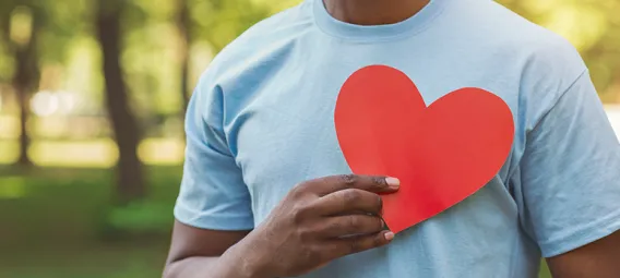 Black man holding red heart on his chest