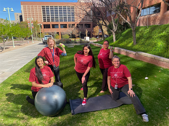 A group of women with a yoga ball and mat, stretching