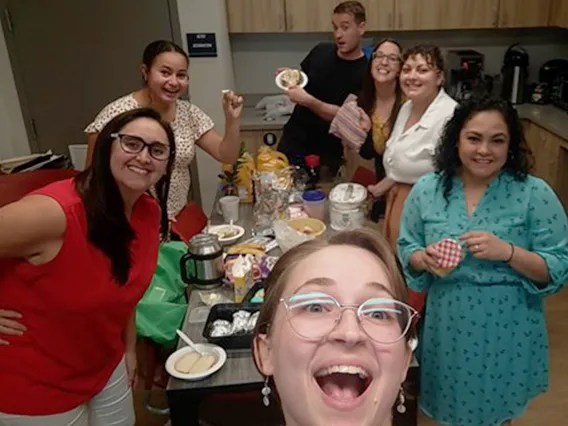 A group of colleagues in the kitchen eating baked potatoes