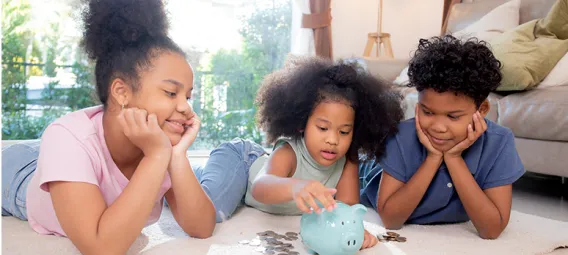 African-American children saving money in piggy bank for planning future financial success