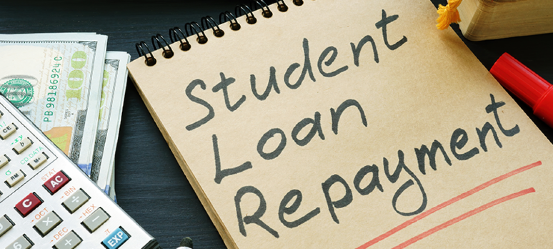 Student loan repayment sign, notepads, calculator and cash