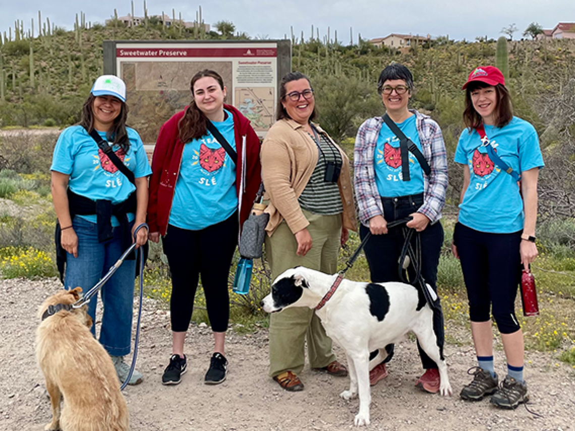 A group of woman in matching t-shirts with two dogs at Sweetwater Reserve