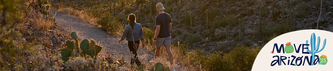 two people walking down a path in the desert