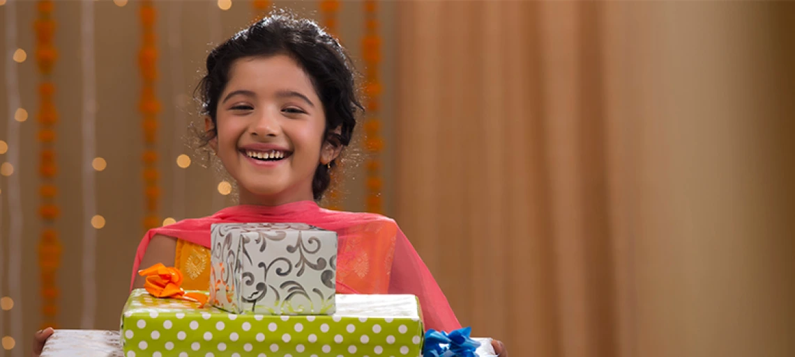 Smiling young person holding stack of colorful wrapped gift boxes, representing gift-giving and special occasions for children