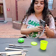 A staff member creating a flower with glow in the dark green play-doh