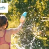 Little girl in swimwear, father play water pistols,