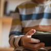 Young boy sitting on a couch with a handheld device
